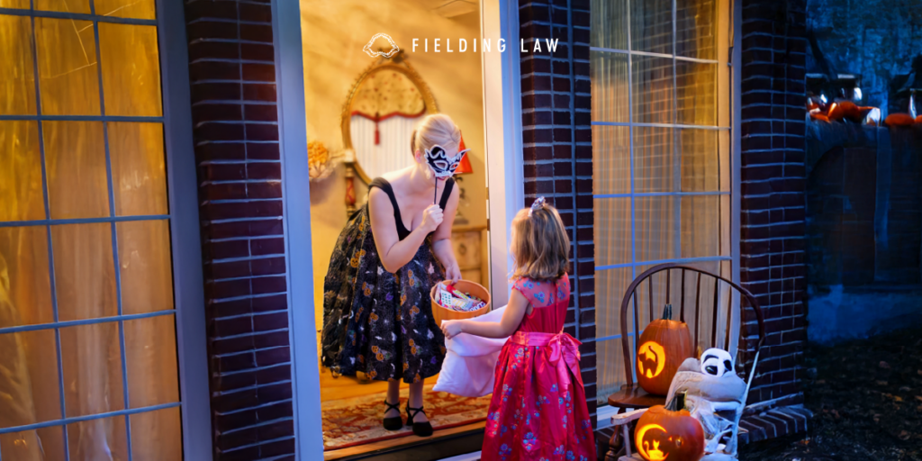Front Door with a lady giving halloween candy to a child