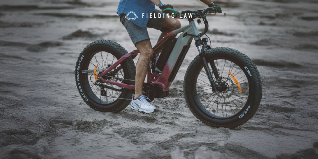 Person riding an e-bike on sand