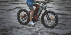 Person riding an e-bike on sand