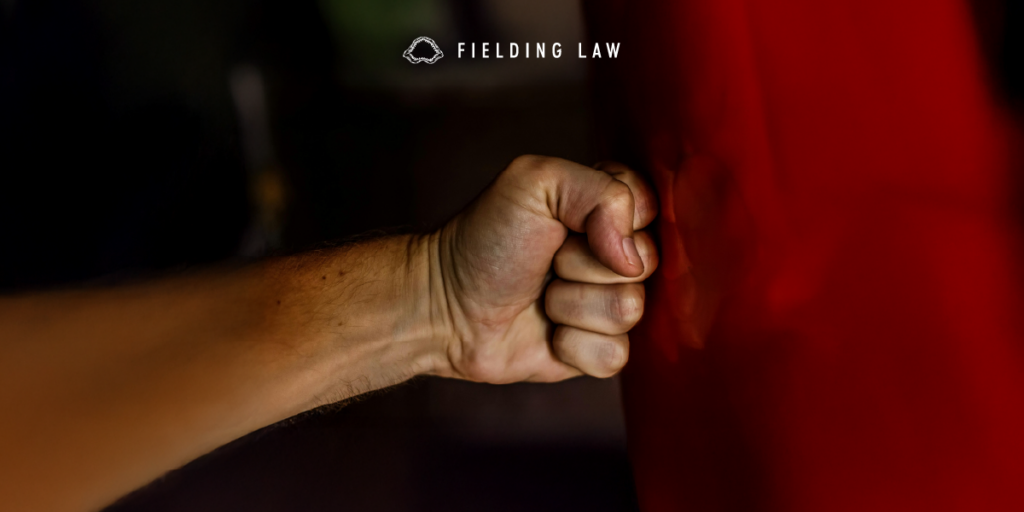 Someones fist punching red metal