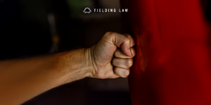 Someones fist punching red metal