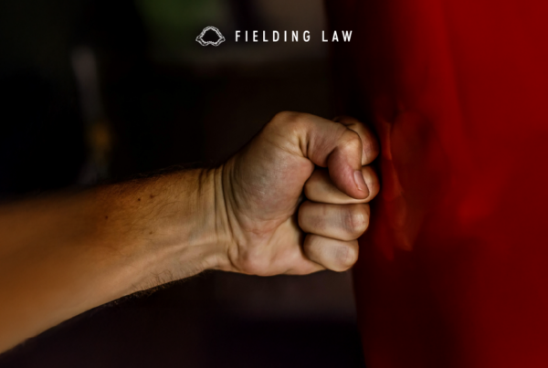 Someones fist punching red metal