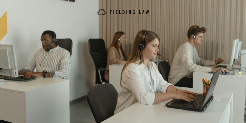 Insurance adjuster sitting at desks with headsets on