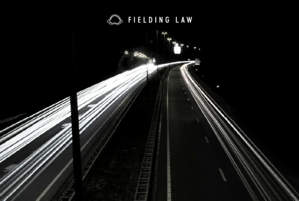 cars driving on a highway at nighttime
