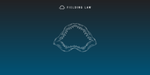 Navy blue gradient background with a Fielding Law Shark Jaw logo