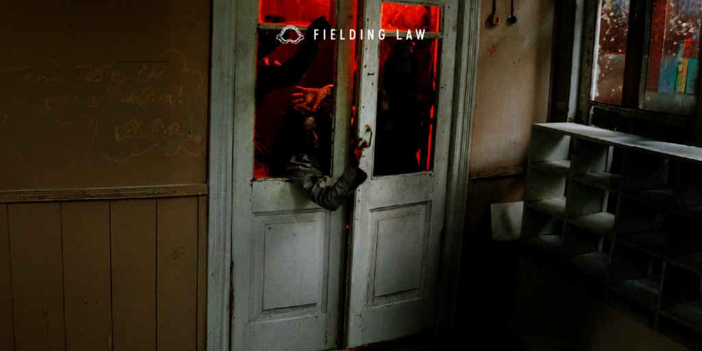 People reaching through the door of a haunted house