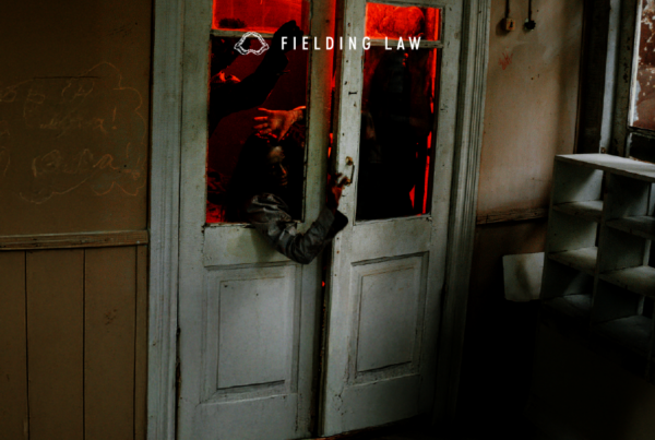 People reaching through the door of a haunted house