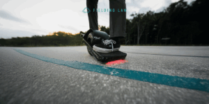 someone riding a onewheel skateboard on a college campus