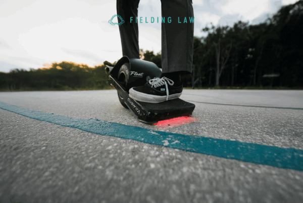 someone riding a onewheel skateboard on a college campus
