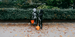 Two Trick-or-Treats on the sidewalk with greenery