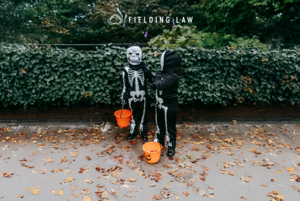 Two Trick-or-Treats on the sidewalk with greenery