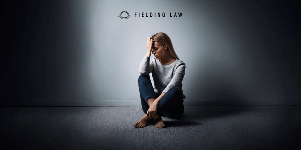 a woman sitting in a dark room looking sad