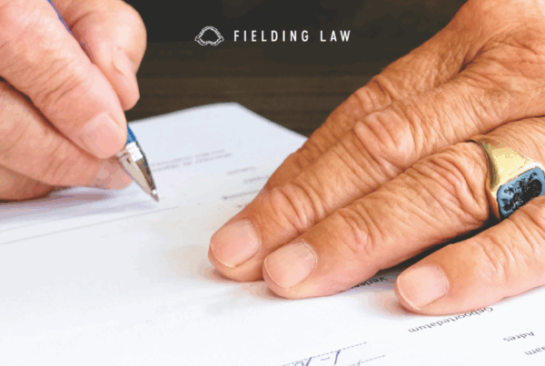 two hands signing a piece of paper