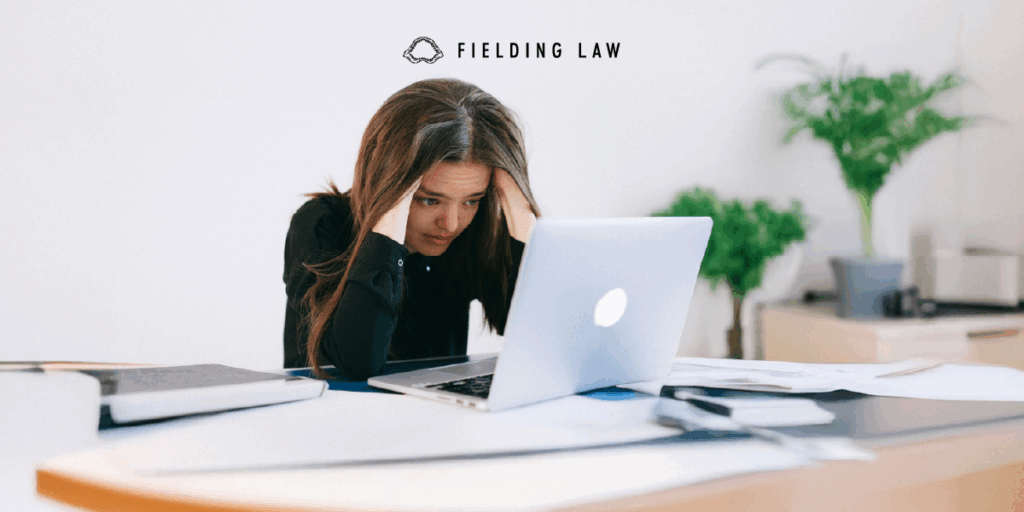 A person looking at a computer screen stressed out