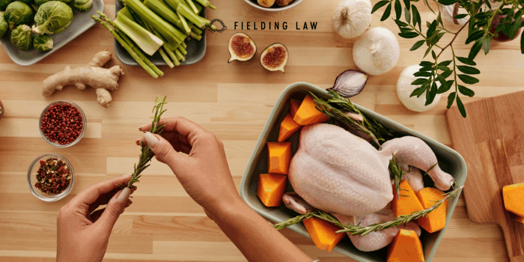 person cooking a turkey with herbs and other food