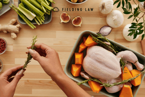 person cooking a turkey with herbs and other food