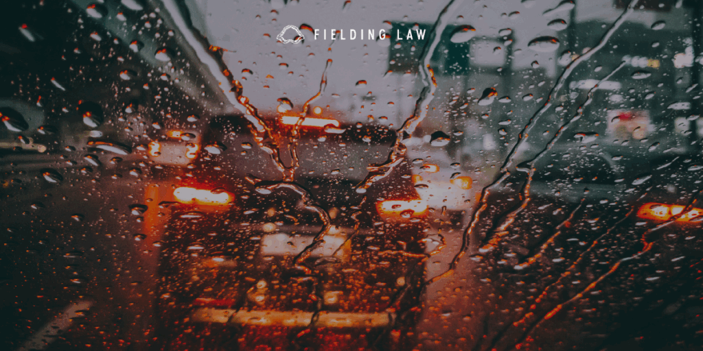 Looking through a rain covered windshield with low visibility at a car in front