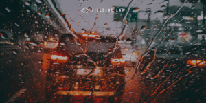 Looking through a rain covered windshield with low visibility at a car in front