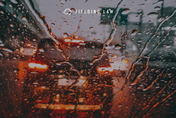 Looking through a rain covered windshield with low visibility at a car in front