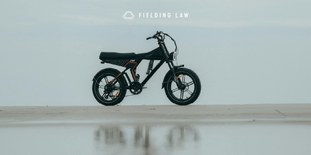 E-Bike standing upright on pavement with a blue sky behind it